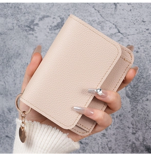 Close-up of light pink lychee pattern leather card holder with gold keychain ring