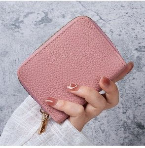 Close-up of a pink litchi grain PU leather card holder with a gold zipper closure