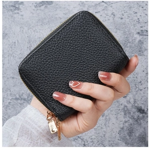 Close-up of black pebble grain PU leather card holder with dual gold metal zippers