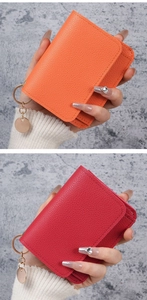 Detail of lychee pattern leather card holders in orange and deep pink with metal charms