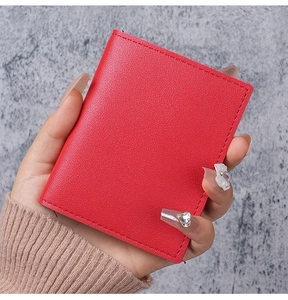Close-up of red pebbled leather slim card holder showing fine stitching and texture