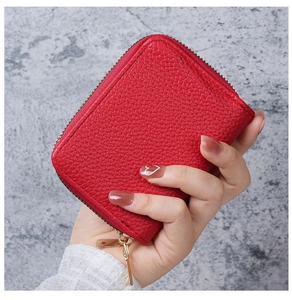 Close-up of red lychee textured PU leather card holder with dual golden zippers