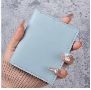 Detail of light blue PU leather card holder featuring white bow and heart-shaped gemstone