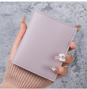 Close-up of slim light purple litchi grain leather card holder held in hand
