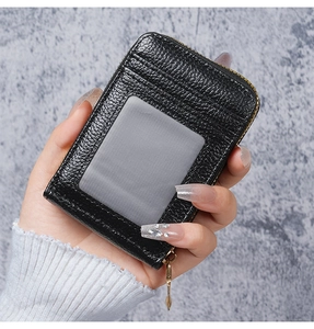Detail of black pebbled leather card holder with gold zipper and transparent ID window