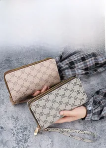 Détail du portefeuille long pour femme avec motif trèfle dégradé et doubles zips dorés