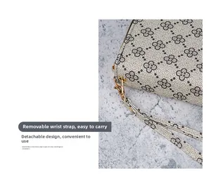 Détail d'un portefeuille long avec dragonne amovible et fermoir mousqueton doré