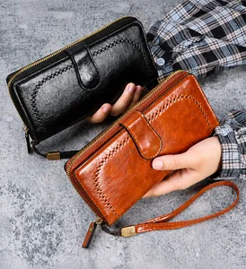 Detail view of large-capacity wax PU leather wallets in black and brown with wrist straps