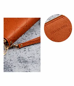 Detail van de oranjebruine litchi-patroon portemonnee met handige polsband en reliëf