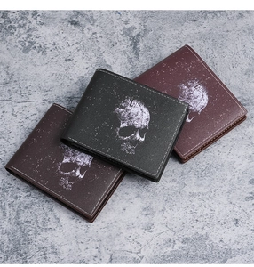 Close-up of retro skull print wallets in black and brown leather with precision stitching