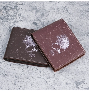Detail of vintage skull print leather bi-fold wallets in brown with contrast stitching