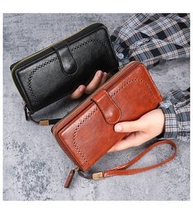 Detail of vintage oil wax PU leather long wallet with heart cutout and wrist strap