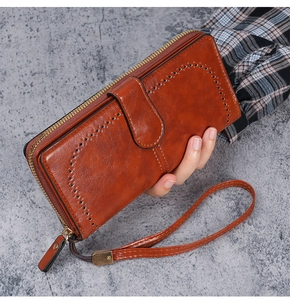 Brown oil wax PU leather long wallet detail with hollow punch pattern and wrist strap