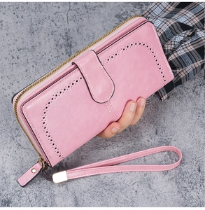 Detail of light pink PU leather long wallet with laser-cut patterns and wrist strap