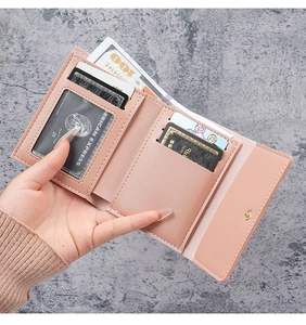 Detail of pink tri-fold PU leather wallet interior with multiple card slots and snap button