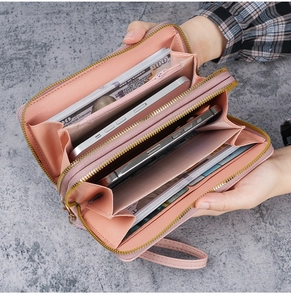 Internal detail of a pink double-zipper wallet showing large capacity and many slots