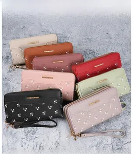 Flat lay of multiple long faux leather zipper wallets in various colors with floral accents