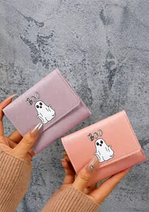 Close-up of cute cartoon ghost wallets in pastel pink and purple with BOO text