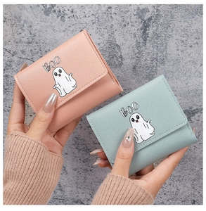 Detailed view of pink and mint green tri-fold wallets featuring cartoon ghost patterns