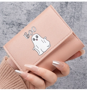 Close-up of pink leather trifold wallet with white cartoon ghost and BOO print detail