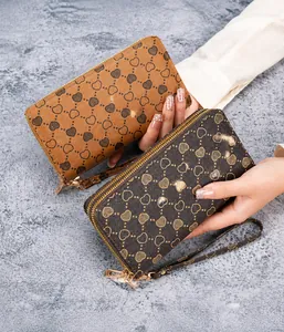 Close-up of double-zipper long wallets with heart patterns and gold hardware