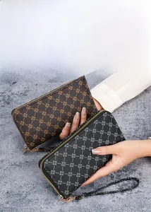 Detail of long zip-around wallets with floral geometric patterns and wrist straps