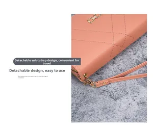 Detail of coral pink quilted long wallet showing detachable wrist strap and gold hardware