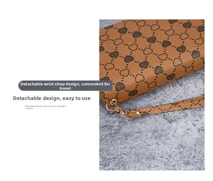 Detail of long brown leather wallet with heart pattern and detachable gold lobster clasp strap