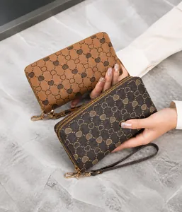 Macro shot of long double-zipper wallet with heart monogram print and wristlet strap