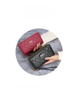 Close-up of quilted long wallets in burgundy and black with gold buckle hardware
