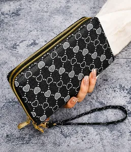 Close-up of double zipper women long wallet with heart print and wrist strap detail