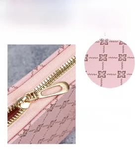 Detail of pink long wallet with floral leather texture and premium gold metal zipper