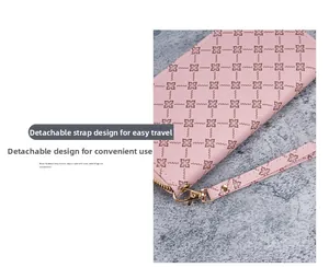 Detail of pink floral embossed wallet with detachable wrist strap and gold zipper