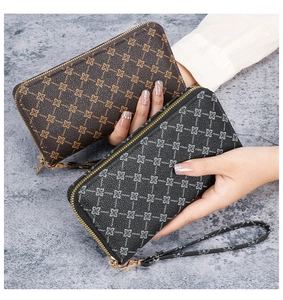 Detail of long zip-around wallets in brown and black with geometric patterns and wrist strap