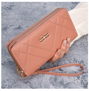 Detail of coral pink quilted long wallet for women with dual zippers and wrist strap