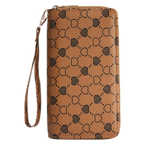 Brown long leather wallet with heart print and wristlet strap shown in front view
