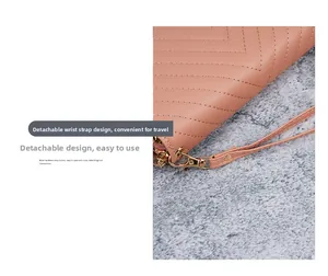 Detail of V-quilted faux leather wallet with detachable golden wrist strap clip