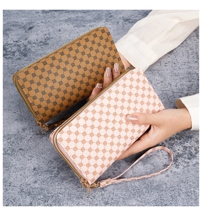 Detail of printed PU leather long clutch wallets in brown and pink with wrist straps