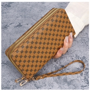 Detailed close-up of brown PU leather long wallet with geometric floral pattern and wristlet