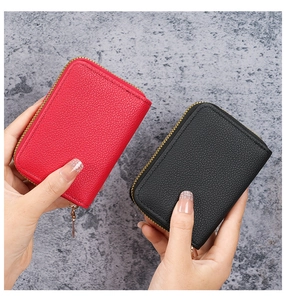 Detailed shot of red and black pebble grain card holders with gold zippers