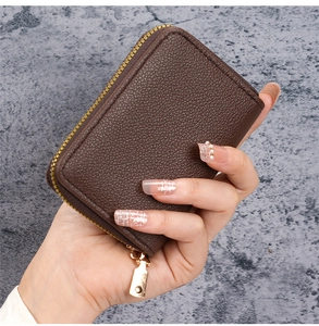 Close-up of a dark brown lychee texture leather wallet with a golden U-shaped zipper