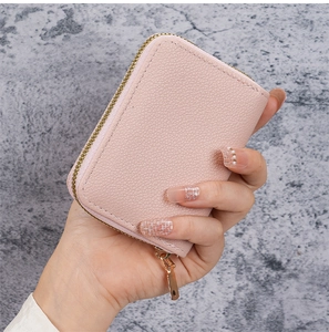Close-up of a pink litchi texture leather card holder with a golden U-shaped zipper