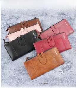 Vue à plat de plusieurs portefeuilles longs en similicuir rétro marron, rose et noir zippés