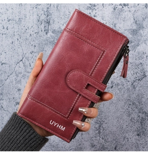 Vue macro d'un long portefeuille bordeaux en cuir PU avec texture fine et logo UYHM