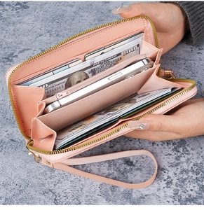 Détail d'un portefeuille long rose avec fentes pour cartes et poche zippée pour femme