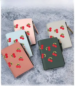 Detail of short leather wallets with cherry embroidery in various stylish pastel colors