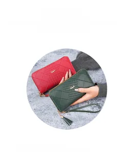 Détail du portefeuille long matelassé avec dragonne, fermeture éclair et gland en rouge et vert