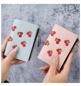 Close-up of cherry embroidery and lychee texture on pink and blue short wallets