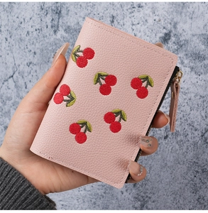 Close-up of pink cherry embroidered wallet showing high-quality lychee grain leather texture