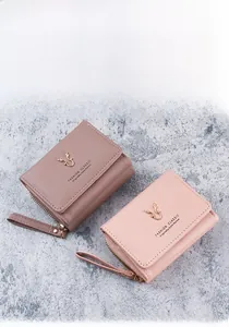 Detail of PU leather wallet with golden deer head metal logo and zipper wrist strap